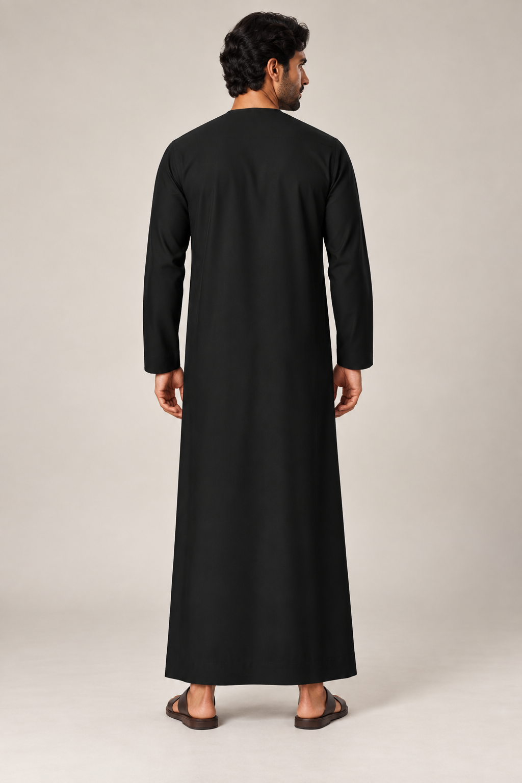 Back view of a male model wearing the Black Emirati thobe with a straight full-length silhouette