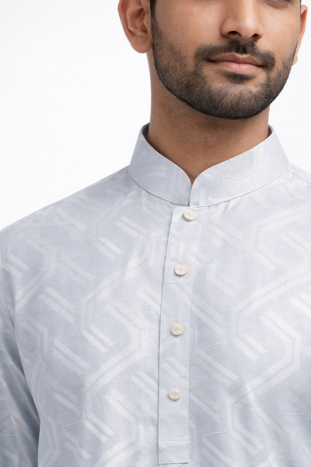 Man wearing a light gray patterned shirt with a white background